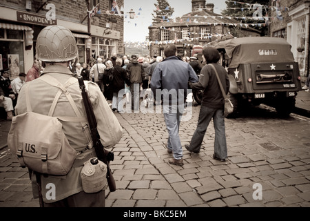 Ein Mann als US-Soldat verkleidet steht auf einer gepflasterten Straße während einer Veranstaltung der 1940er Jahre in Haworth, Vereinigtes Königreich Stockfoto