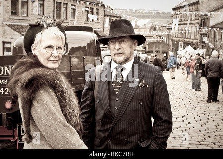 Zwei Personen in der 1940er Jahre Kostüm stehen neben einem altmodischen LKW bei einem 1940er Jahren Veranstaltungen in Haworth, Vereinigtes Königreich Stockfoto