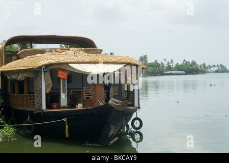 Ein Hausboot mit Sonnendeck, von der Seite auf den Backwaters in Kerala verankert Stockfoto