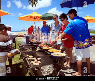 Barbecue am Strand von Nevis, für die Passagiere auf dem Kreuzfahrtschiff vor Anker in der Ferne. Stockfoto