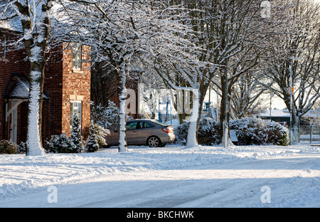 Schneebedeckten Rasen und Straße in einer Wohnstraße in Hawarden, Nordwales Stockfoto