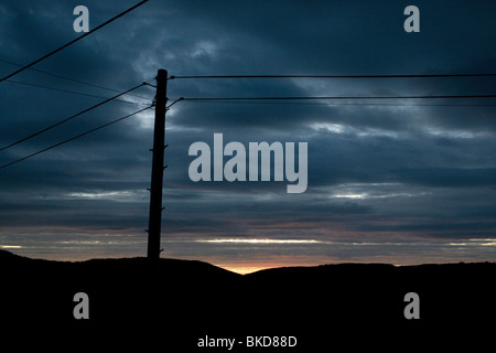 Sonnenuntergang und Silhouette macht Powerlines in Wales. Stockfoto