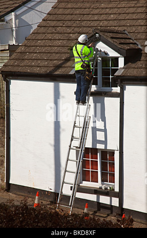 British Telecom Ingenieur auf Leiter Reparatur Telefonleitung zu Haus Wales UK Stockfoto