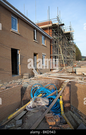 Häuser auf neue Wohnsiedlung mit Rohrleitungen zeigt Abergavenny Wales UK Stockfoto