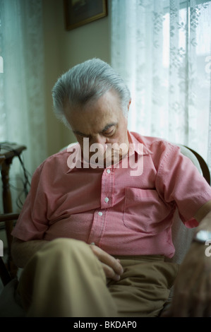 Alter Mann schlafen im Wohnzimmersessel Stockfoto