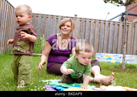 Eine Mutter und ihre zwei Kinder zahlen außerhalb in ihrem Hinterhof. Stockfoto