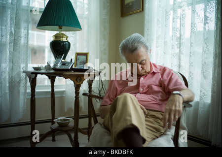 Alter Mann schlafen im Wohnzimmersessel Stockfoto