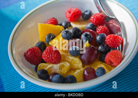 Nahaufnahme der Schüssel mit gemischten frischen Früchten mit Heidelbeeren Himbeeren Orangen Trauben und Bananen Stockfoto