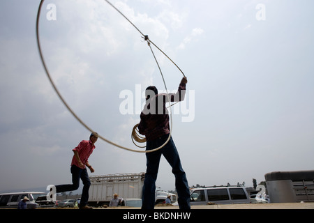 Ein Junge versucht, seinen Freund während einer Escaramuza Frauen Rodeo in Chalco am Stadtrand von Mexiko-Stadt lasso Stockfoto