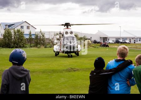 Menschen versammeln sich um einen Hubschrauber von der isländischen Küstenwache, Vogar in Vatnsleysustrond, Island. Stockfoto