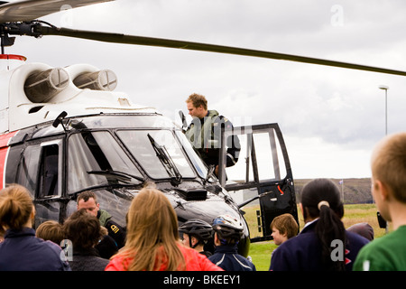 Menschen versammeln sich um einen Hubschrauber von der isländischen Küstenwache, Vogar in Vatnsleysustrond, Island. Stockfoto