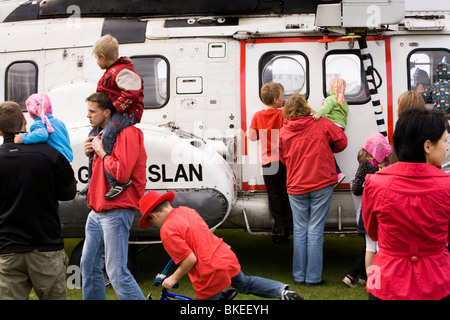 Menschen versammeln sich um einen Hubschrauber von der isländischen Küstenwache, Vogar in Vatnsleysustrond, Island. Stockfoto