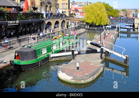 Blick auf sonnige Stadtlandschaft bei Schmalboot Abfahrt Camden Schleuse auf dem Regents Canal mit weinenden Weidenbäumen dahinter North London, England, Großbritannien Stockfoto