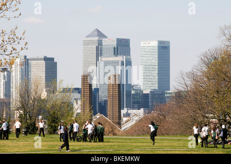 Schulkinder in Greenwich Park mit Blick auf Canary Wharf und die Docklands, London Stockfoto