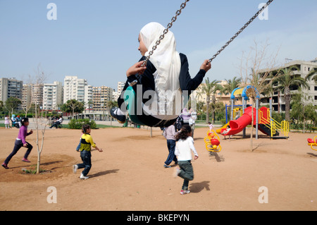 KINDER UND ELTERN SPIELEN IN A PARK IN TRIPOLI, LIBANON Stockfoto