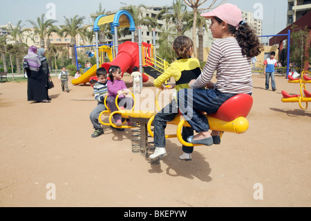 KINDER UND ELTERN SPIELEN IN A PARK IN TRIPOLI, LIBANON Stockfoto