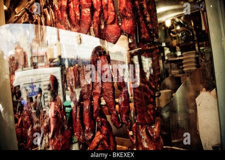 Streifen von gekochtem Schweinefleisch und Gans hängen in einem chinesischen Restaurant am 40th Avenue, Chinatown, Flushing, New York, USA Stockfoto