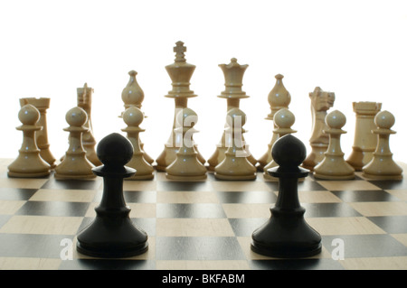 Schach. Zwei schwarze Bauern vor weißen Figuren auf dem Schachbrett Stockfoto