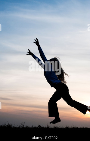 Young Girl energetisch Spaß springen und laufen herum. Silhouette Stockfoto