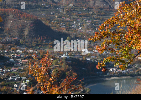 Weißen Bauernhäuser und öffentliche Gebäude verstreut in Obstgärten von Birne, die ein helles rot im Herbst in Jinchuan in China zu machen. Stockfoto