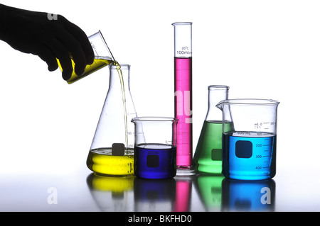 Labor Glaswaren mit verschiedenen farbigen Flüssigkeiten vor einem neutralen Hintergrund Stockfoto