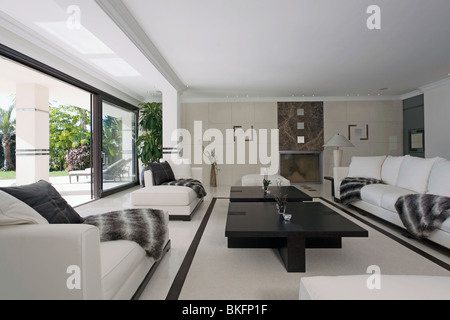 Schwarz + weiß wirft auf weißen Sofas in großen modernen weißen Wohnzimmer Couchtisch schwarz mit schwarz + weiß Bodenbelag Stockfoto