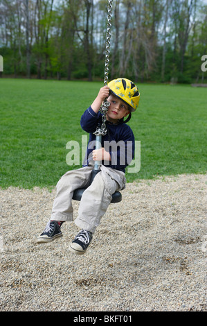 Ein junges Kind junge Reiten einen Spielzeug Seil Weg Spielplatz Sommer Stockfoto
