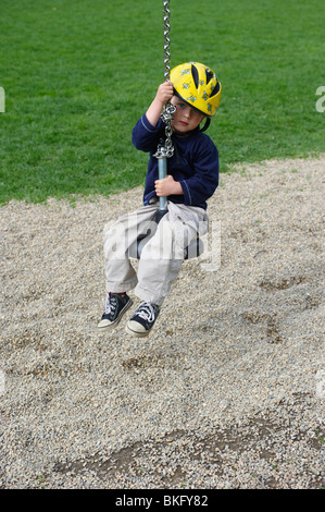 Ein junges Kind junge Reiten einen Spielzeug Seil Weg Spielplatz Sommer Stockfoto