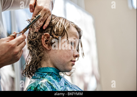 Kleiner Junge, seine Haare schneiden. Stockfoto