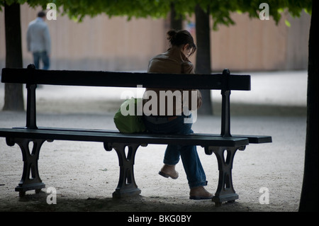 Paris, Frankreich, Frau, die Aloe sitzt, von hinten, liest allein auf der Parkbank im Park "Jardin du Palais Royale" Stockfoto
