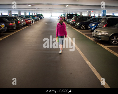 Junge Mädchen, die zu Fuß in mehrgeschossigen Parkplatz, Großbritannien Stockfoto