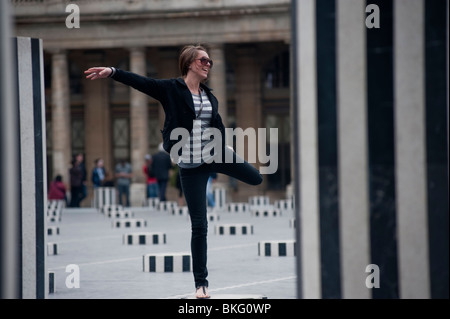 Junge Frau posiert im Jardin de Palais Royale, Gärten, in Paris Frankreich, ('Van Buren' Columns) Stadtkunst paris Stockfoto