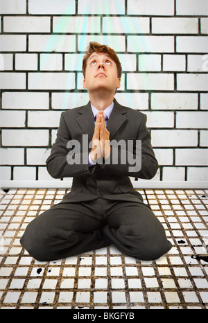 Comic-Geschäftsmann, sitzen auf den Knien betend Stockfoto