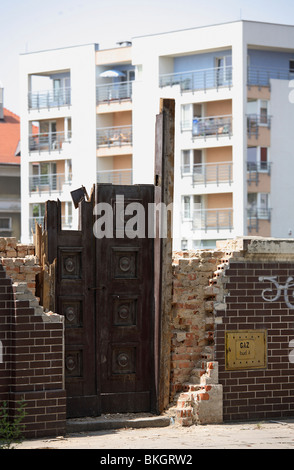 Die Reste eines zerstörten Hauses mit einem modernen Gebäude im Hintergrund. Poznan, Polen Stockfoto