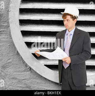 Ingenieur - Designer in den Helm mit den Zeichnungen in der hand Stockfoto