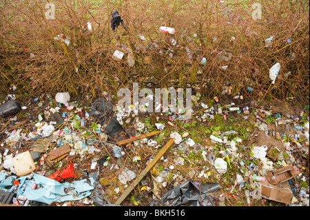 Abfall und Müll abgeladen am Straßenrand Layby Hecke UK Stockfoto