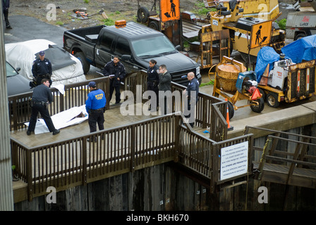 NYPD Offiziere warten auf die Ankunft des Untersuchungsrichters nach dem Entfernen einer Leiche in den verschmutzten Gewässern der Newtown Creek in New York Stockfoto