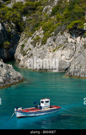 Kleine felsige Bucht mit kristallklarem Wasser und touristischen Boot in Zakynthos, Griechenland Stockfoto