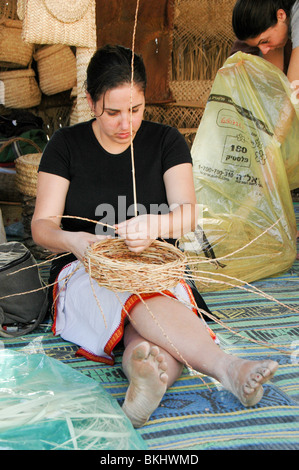 Frau spinnt einen Korb aus Schilf Stockfoto