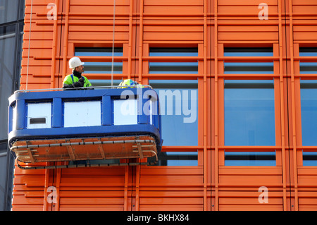 Mann in Wiege Inspektion Verkleidung auf neue Hochhaus Stockfoto