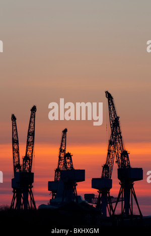 Krane in der Werft von BAE Systems in Govan auf dem Fluss Clyde-Glasgow bei Sonnenuntergang Stockfoto