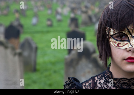 Maskierte Mädchen, das Gesicht verdeckt, In der Kirche Hof, am Whitby Goth Festival, North Yorkshire, Großbritannien, 2010 Stockfoto