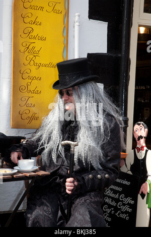 Einnahme von Tee, ein Mann verkleidet Sitz außerhalb Whitby Tee Shop oder Café auf dem Gothic Festival, April 2010 Stockfoto