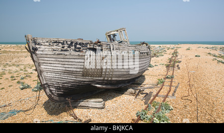 verlassene zerstörten Fischerboot und Motoren auf den Kiesstrand in Dungeness Kent UK Stockfoto