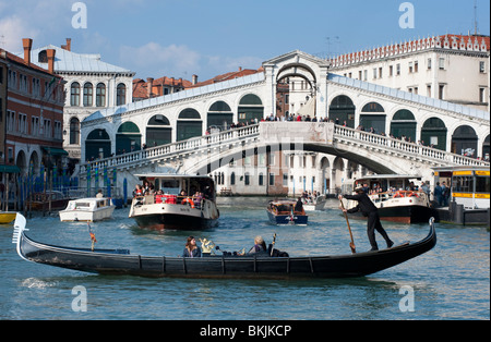 Gondoliere und seine Gondel auf dem Canale Grande am Rialto-Brücke in Venedig Italien Stockfoto