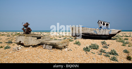 verlassene zerstörten Fischerboot und Motoren auf den Kiesstrand in Dungeness Kent UK Stockfoto