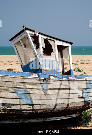 verlassene zerstörten Fischerboot und Motoren auf den Kiesstrand in Dungeness Kent UK Stockfoto