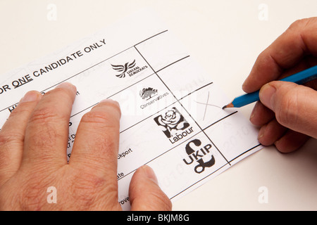 UK-Wahlen Mann stimmberechtigten Arbeit auf Wahlzettel Stockfoto