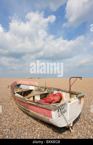 Roten Fischerboot auf einem Kiesstrand bei Cley unter einem strahlend blauen Himmel Stockfoto