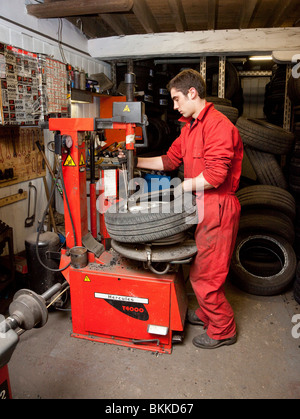 eine Garage Arbeitskraft Reifenwechsel auf einer Auto-Felge Stockfoto